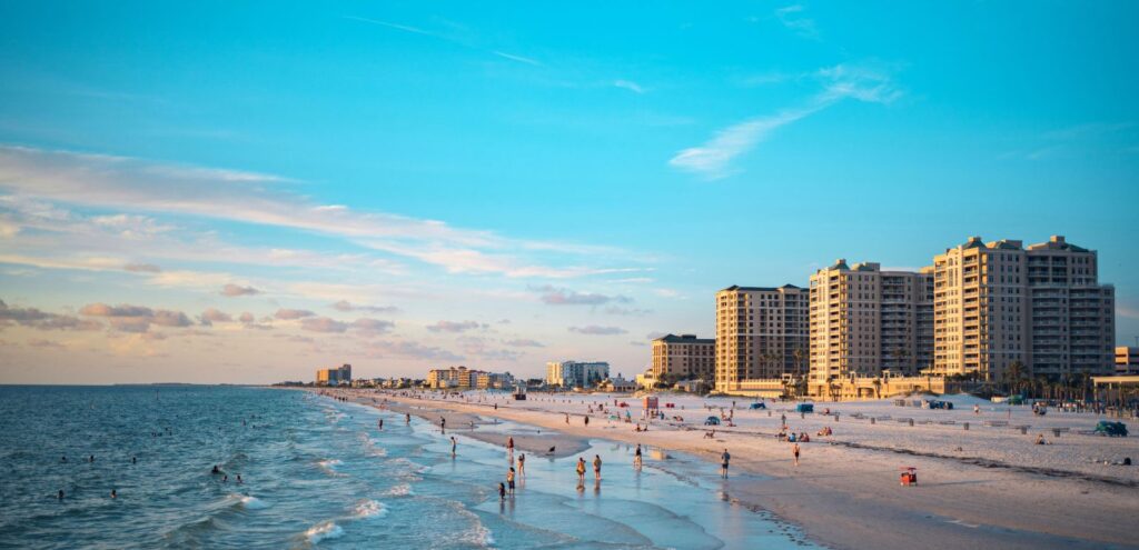 Clearwater Beach with people among the shore and hotels and other buildings along the shoreline