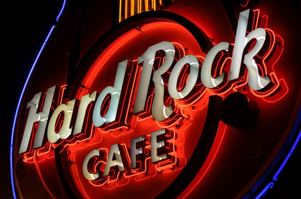 The bottom of a Hard Rock Cafe Guitar Sign with the neon lights lit up